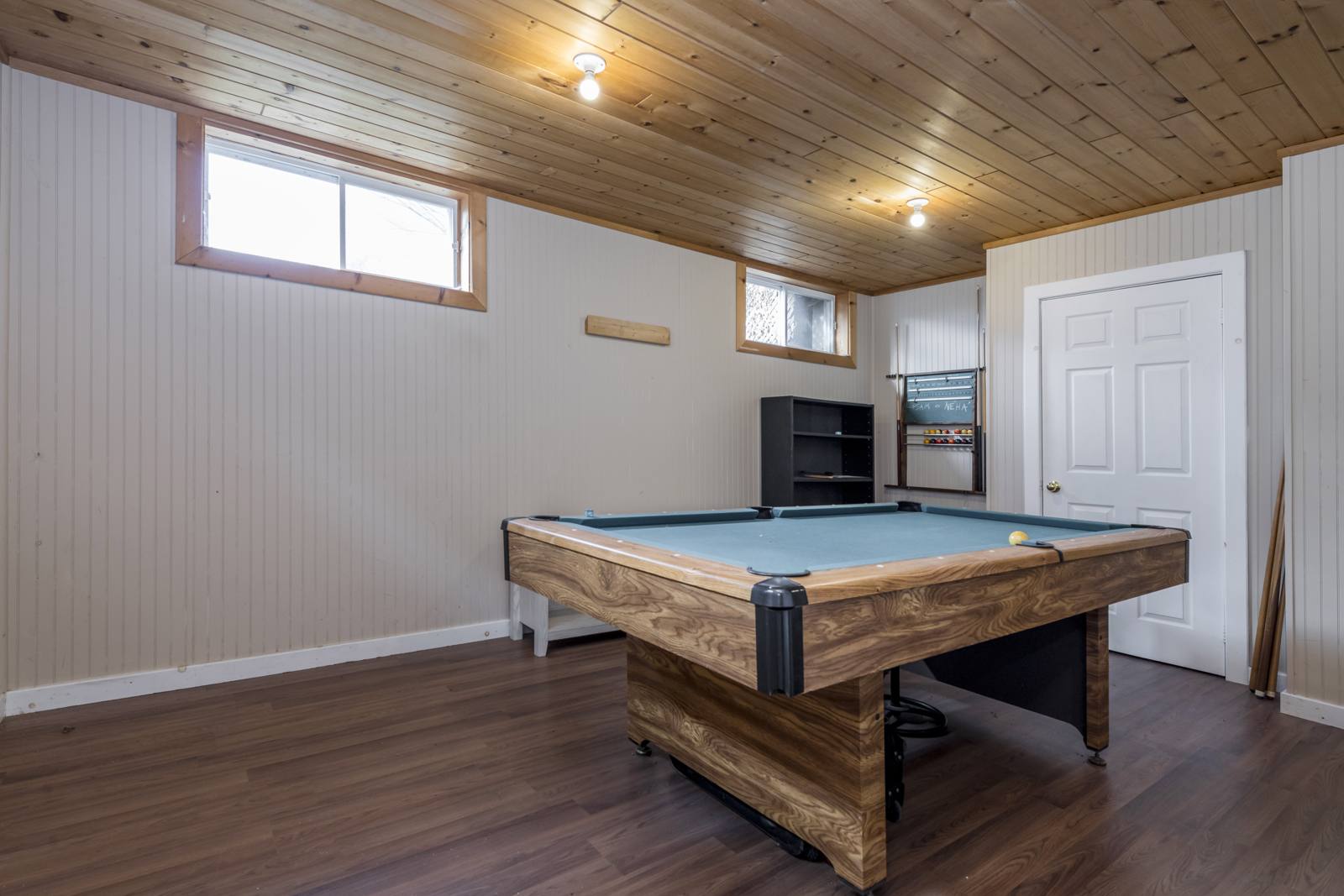 Finished lower-level rec room with a pool table and pine plank ceiling
